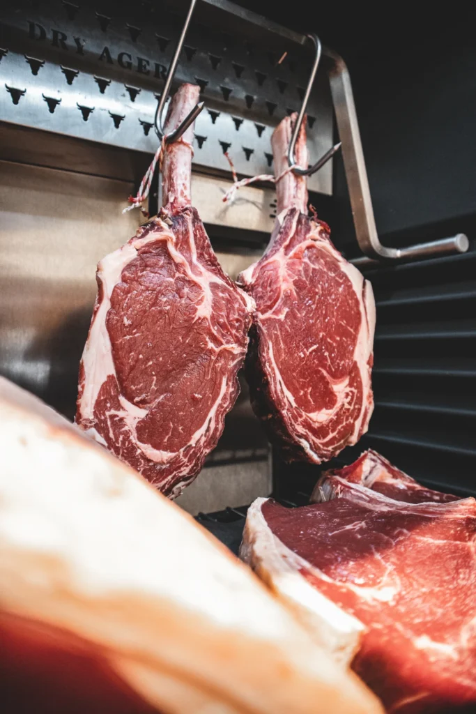 steaks hanging from a hook