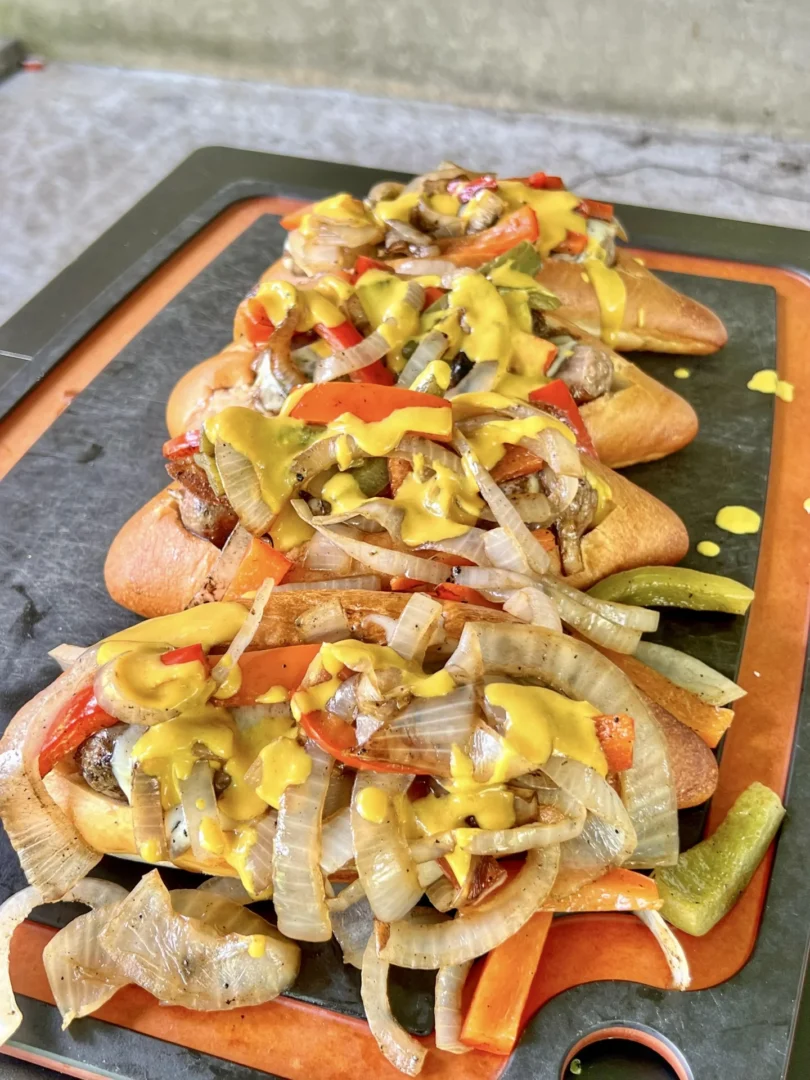 all 3 sausages with peppers on a cutting board