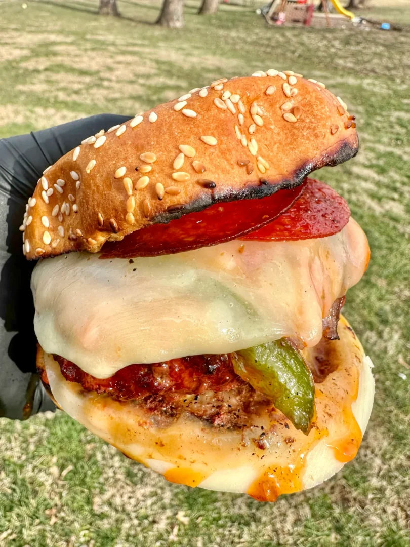 the pizza burger being held