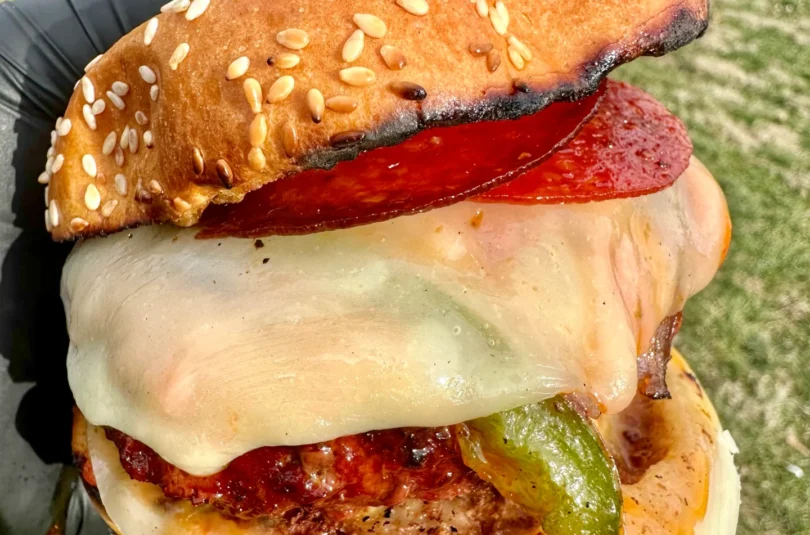 the pizza burger being held