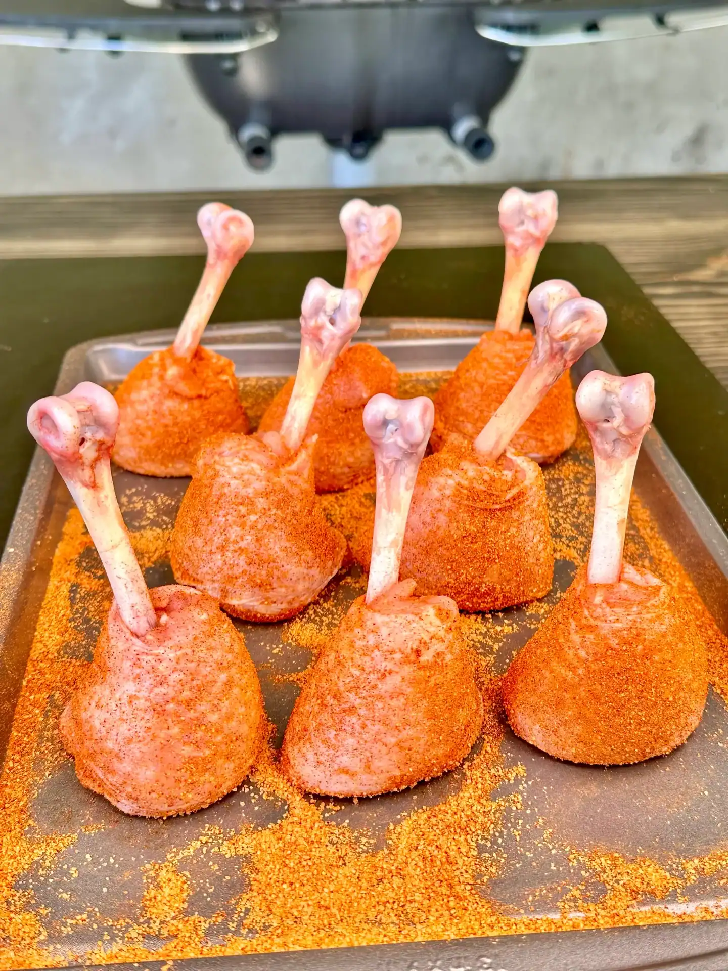 Chicken lollipops coated with duck fat and BBQ seasoning before smoking.