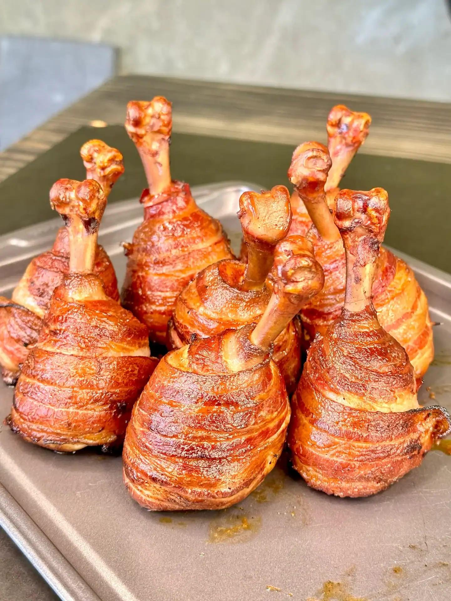 Bacon wrapped chicken lollipops smoked until the bacon is browned