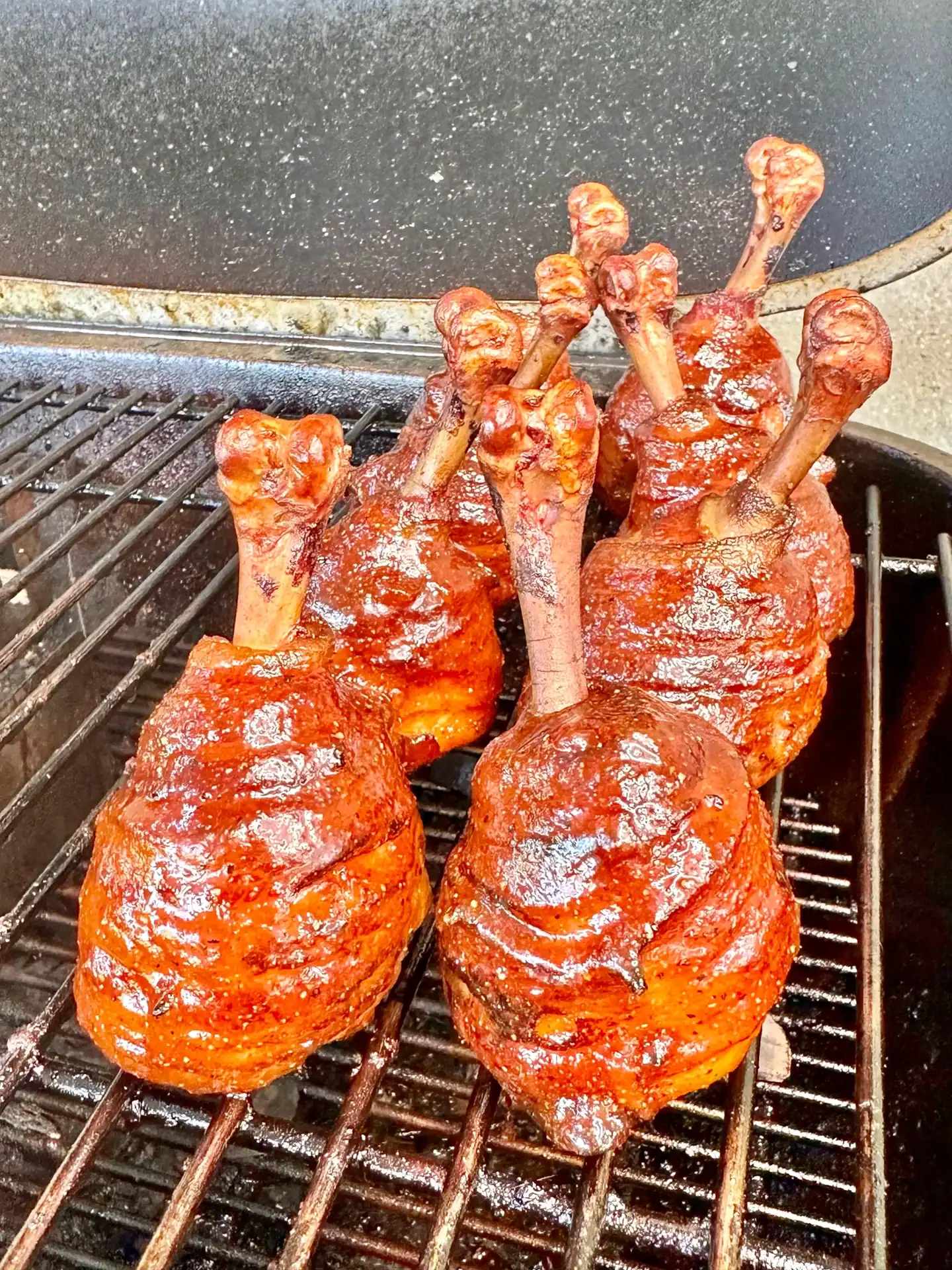 Smoked chicken lollipops wrapped in bacon with BBQ glaze on the smoker