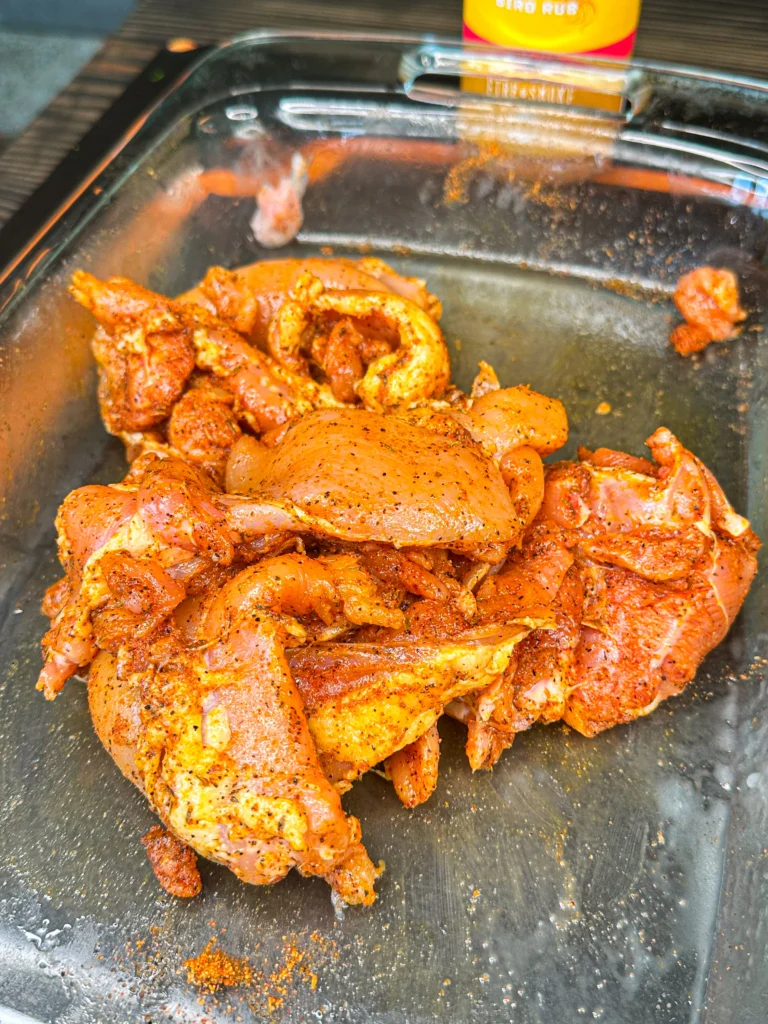 chicken thighs being seasoned 
