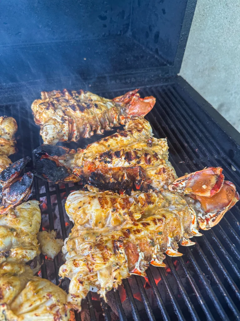 lobster tails on the second side of being grilled