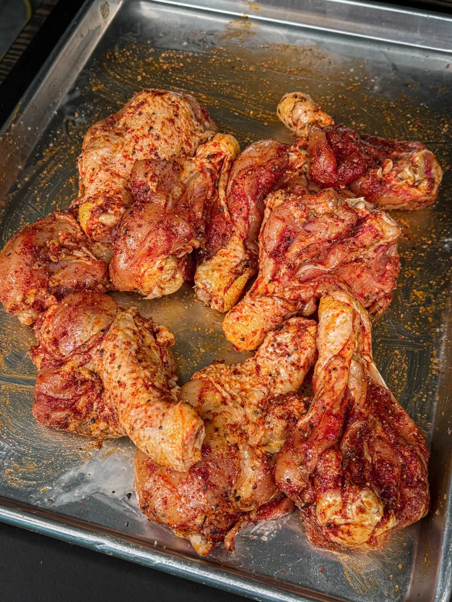 butterflied chicken drumsticks seasoned in a smoky Chipotle seasoning, on a baking dish.