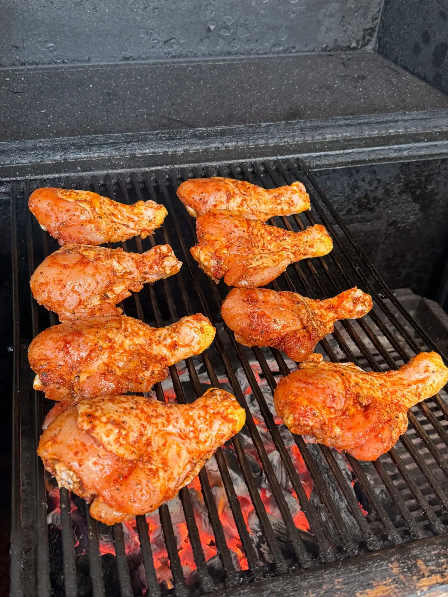 seasoned chicken drumsticks placed over direct heat on a grill.