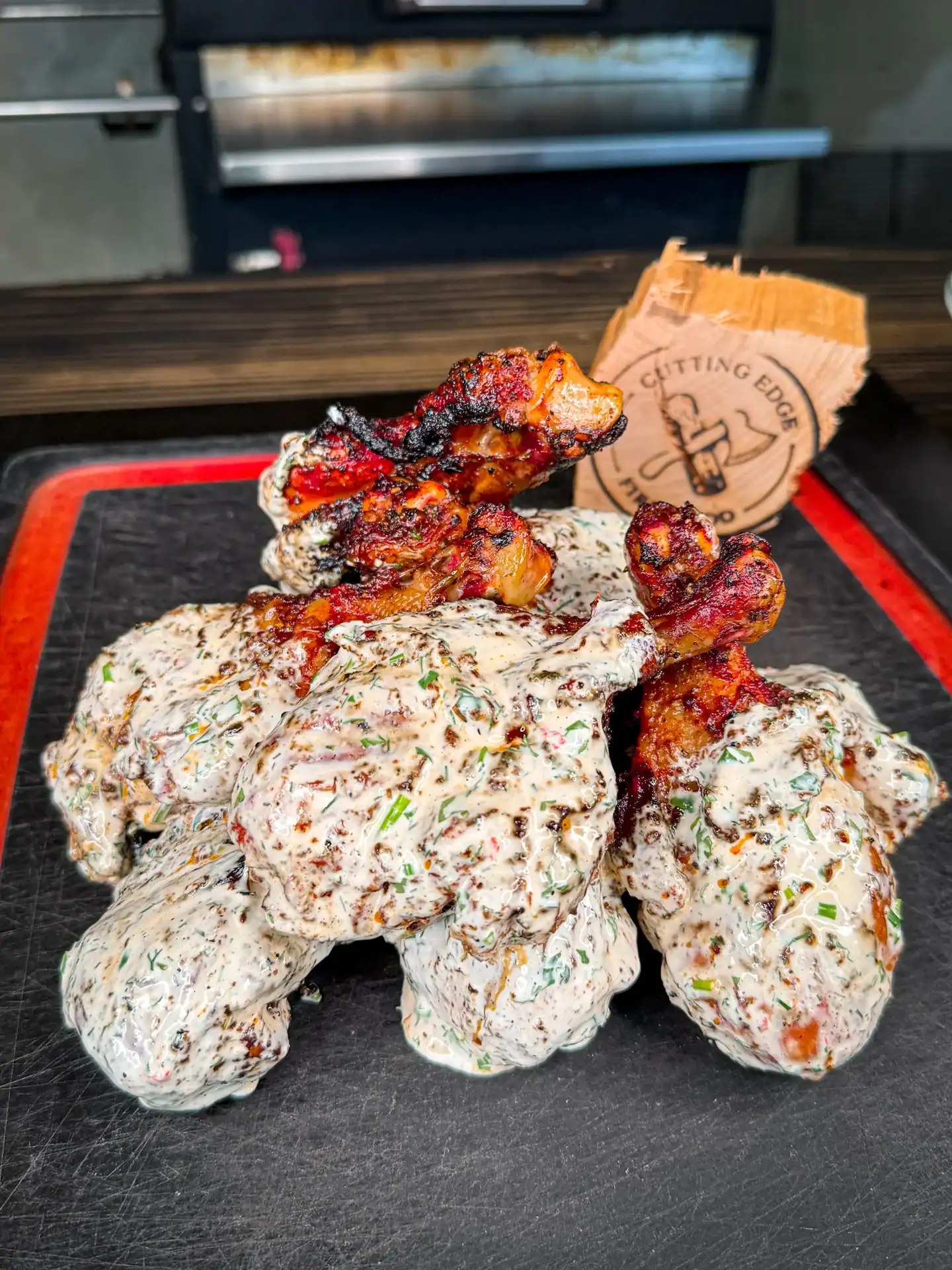 a serving platter featuring grilled chicken drumsticks, dunked in a creamy ranch sauce.