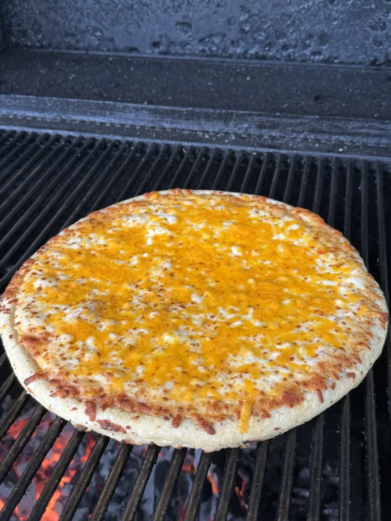 adding cheddar to the pizza