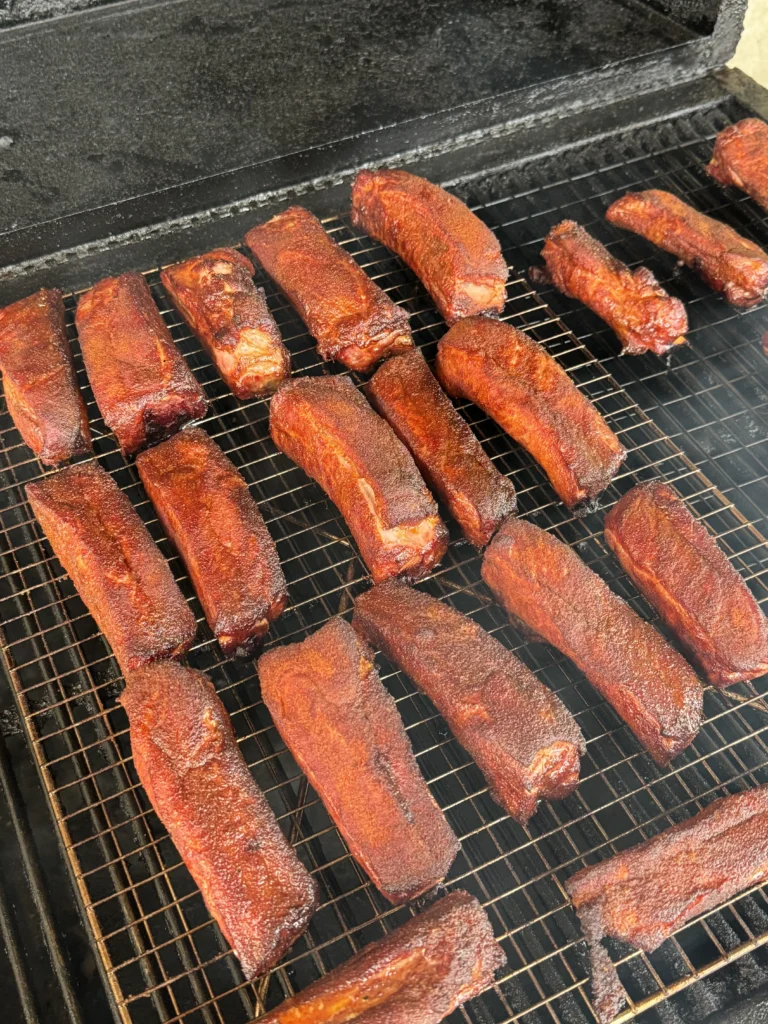 spritzing the party ribs on the smoker