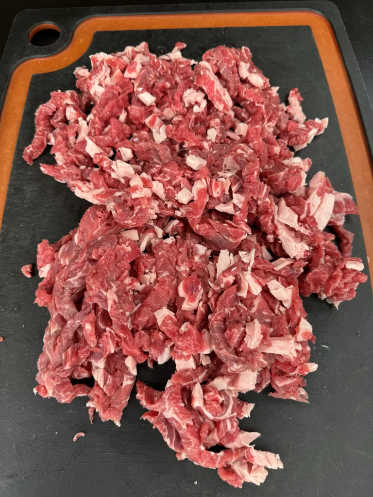 shaved beef on a cutting board