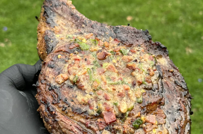steak with candied bacon on it