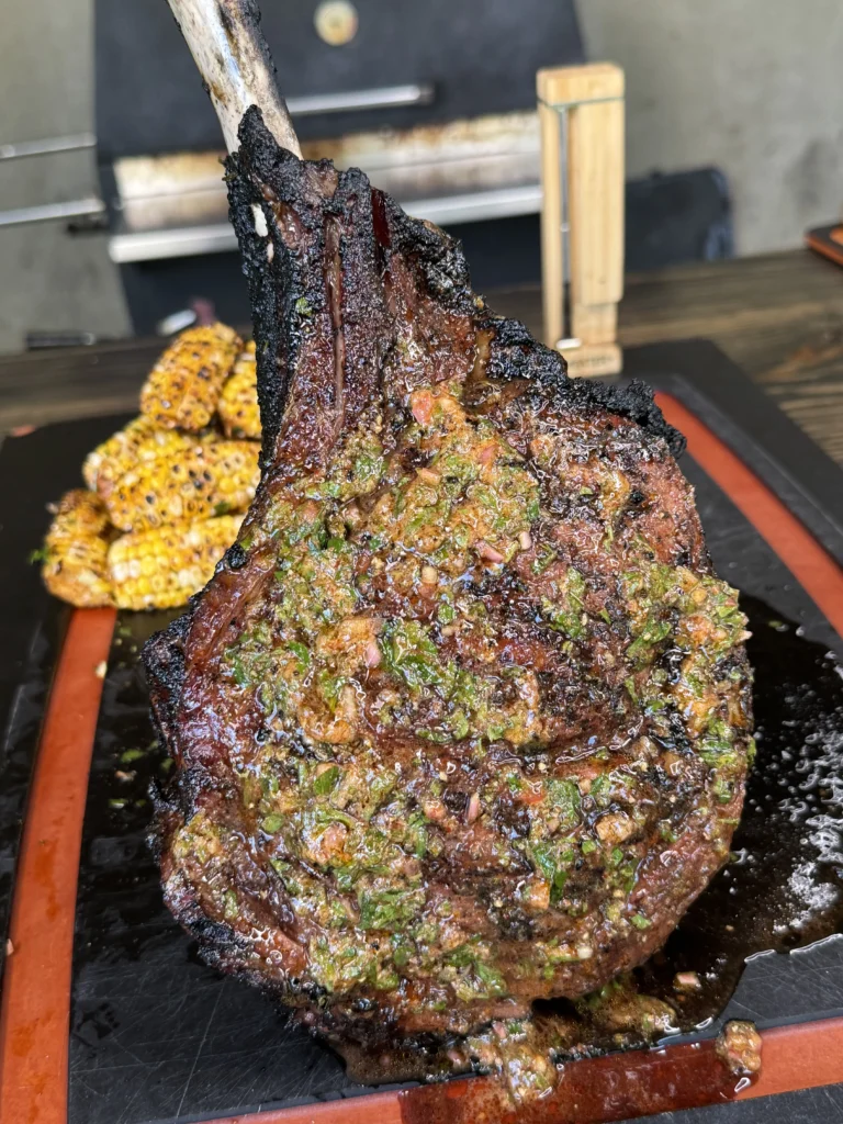 giant steak on cutting board with corn