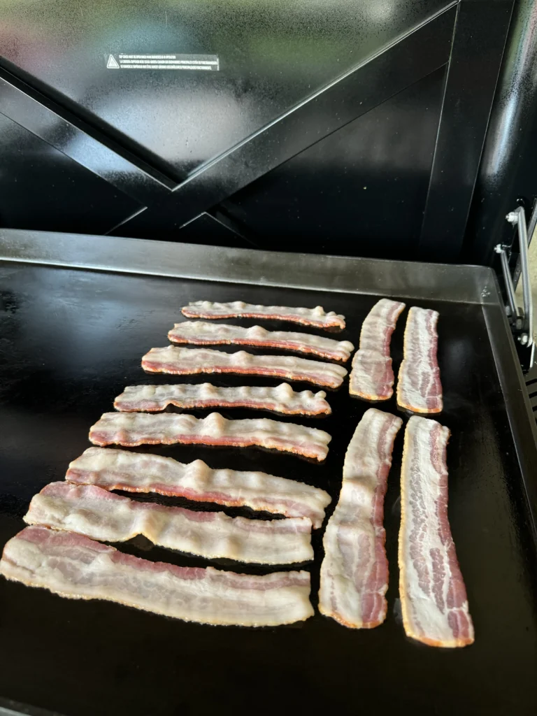 cooking the bacon on the griddle