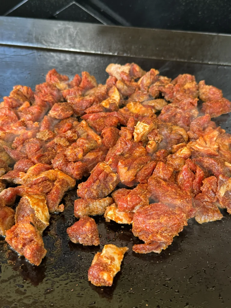 Creole steak cooking on the flat top