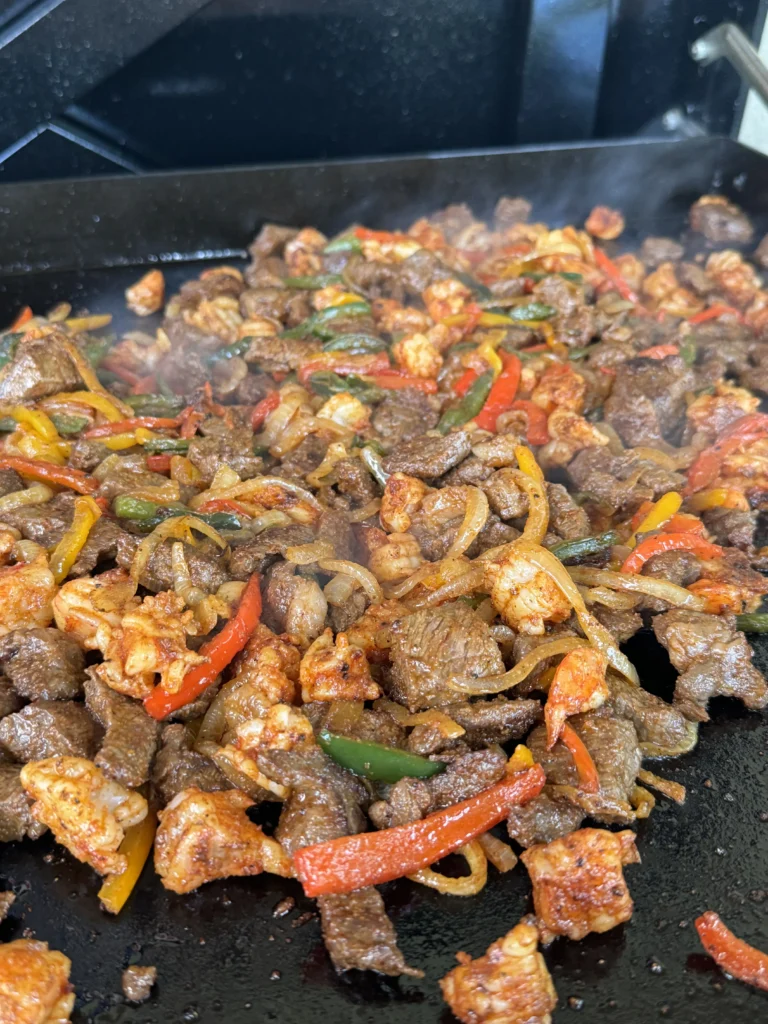shrimp, vegetables and steak cooking together