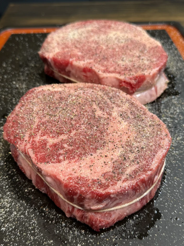 seasoned steaks on the grill