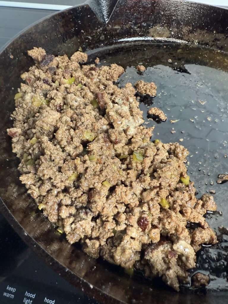cooking the ground beef in a cats iron