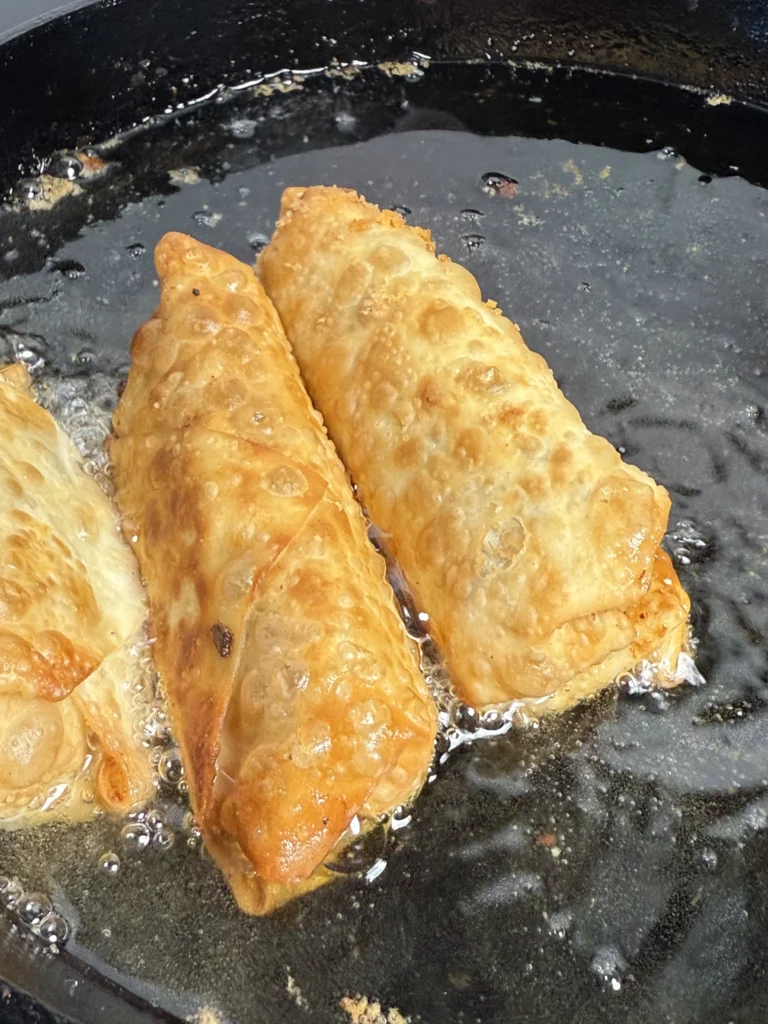 frying the eg rolls in a pan