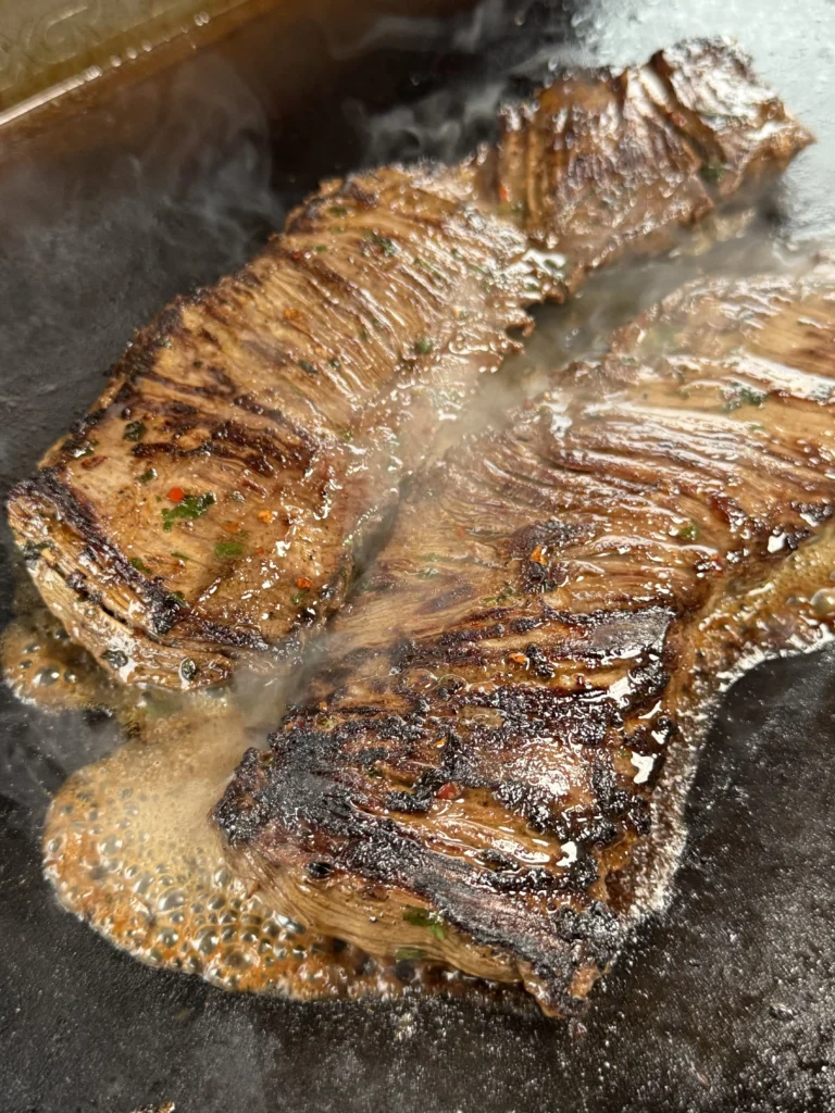 cooking the steak on a cast iron for surf n turf tacos