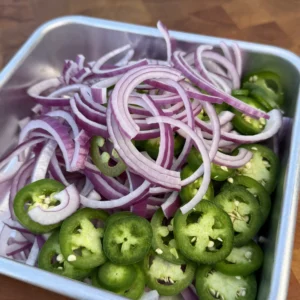 Freshly sliced jalapeños and red onions ready for sautéing