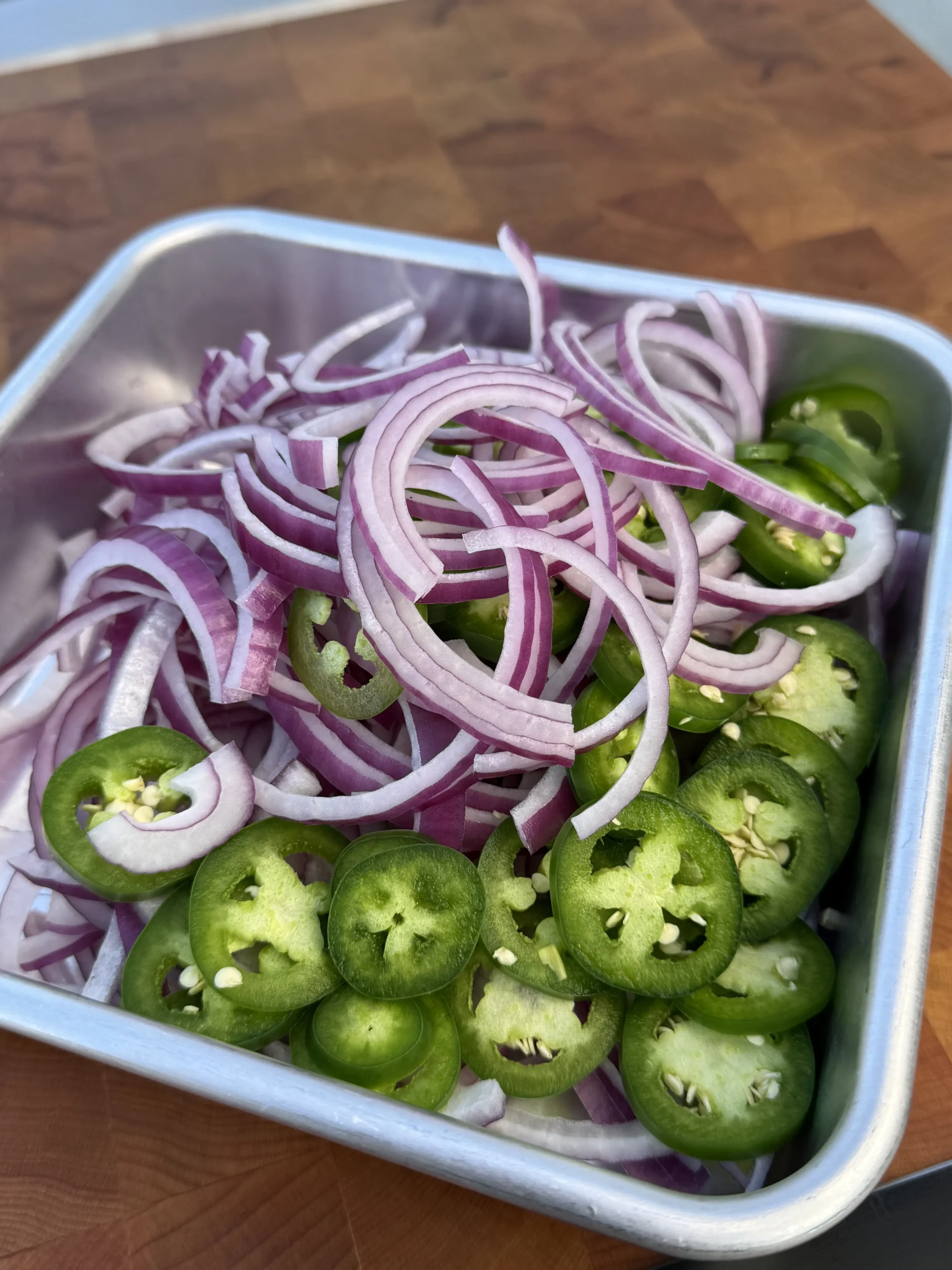 Freshly sliced jalapeños and red onions ready for sautéing