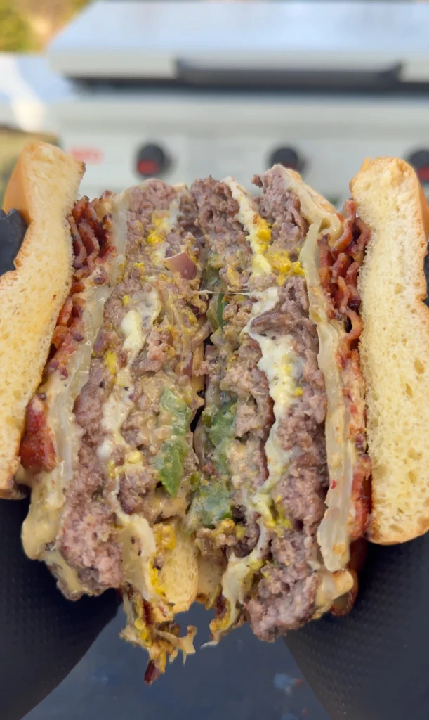 Cut-in-half smash burger showing juicy beef and layers of toppings