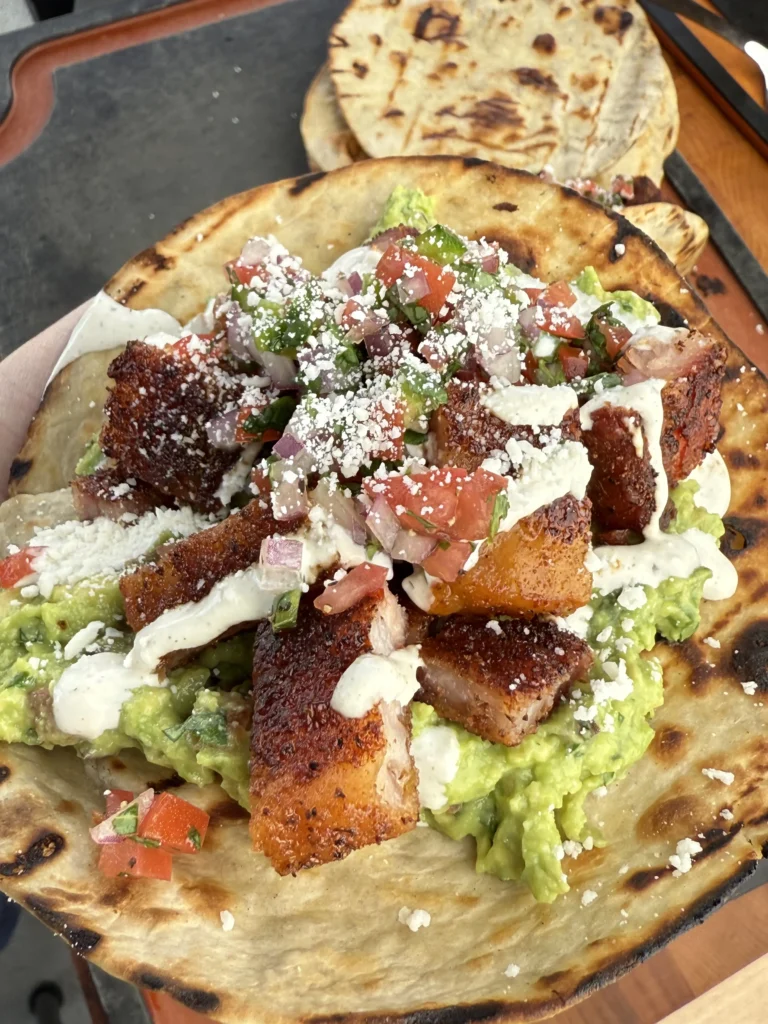 Warm corn tortillas with crispy chicharrón, guacamole, and pico de gallo toppings