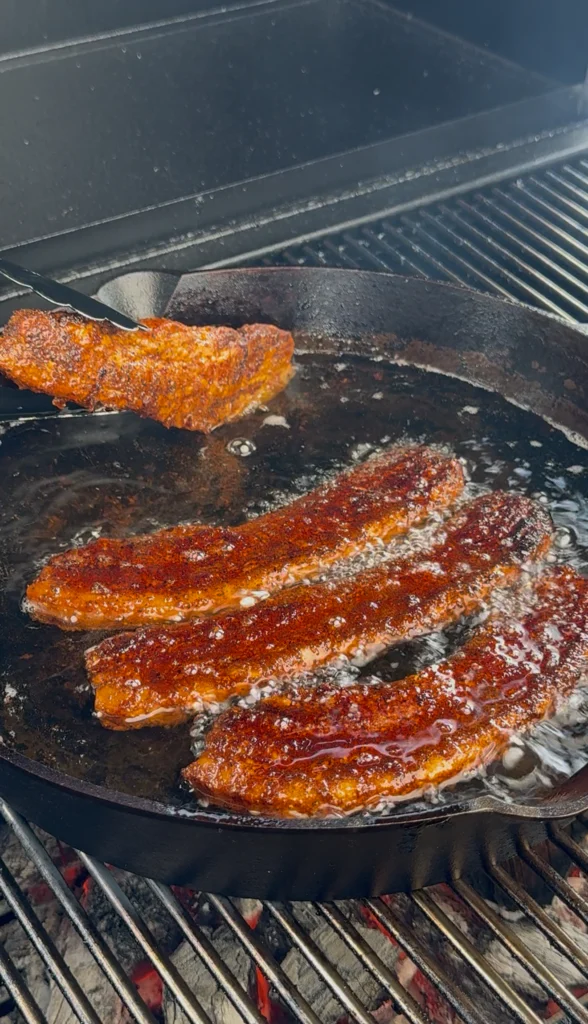 Crispy chicharrón pieces sizzling in hot oil for the perfect crunch