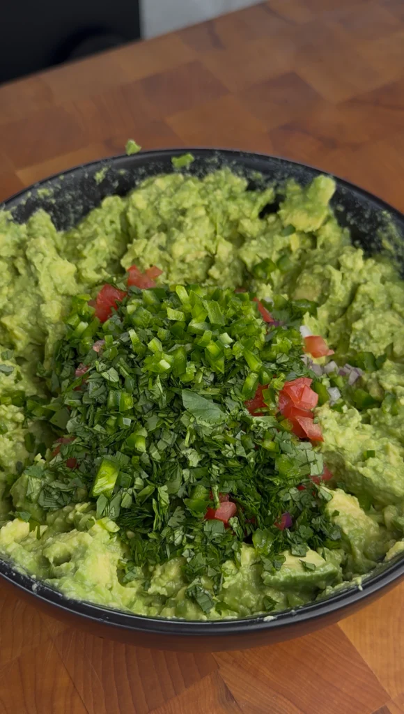 Mixing guacamole ingredients in a bowl with a fork
