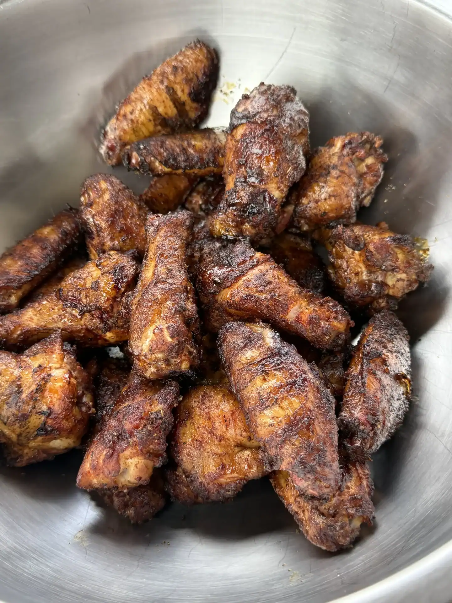 crispy smoked chicken wings placed in a stainless steel bowl.