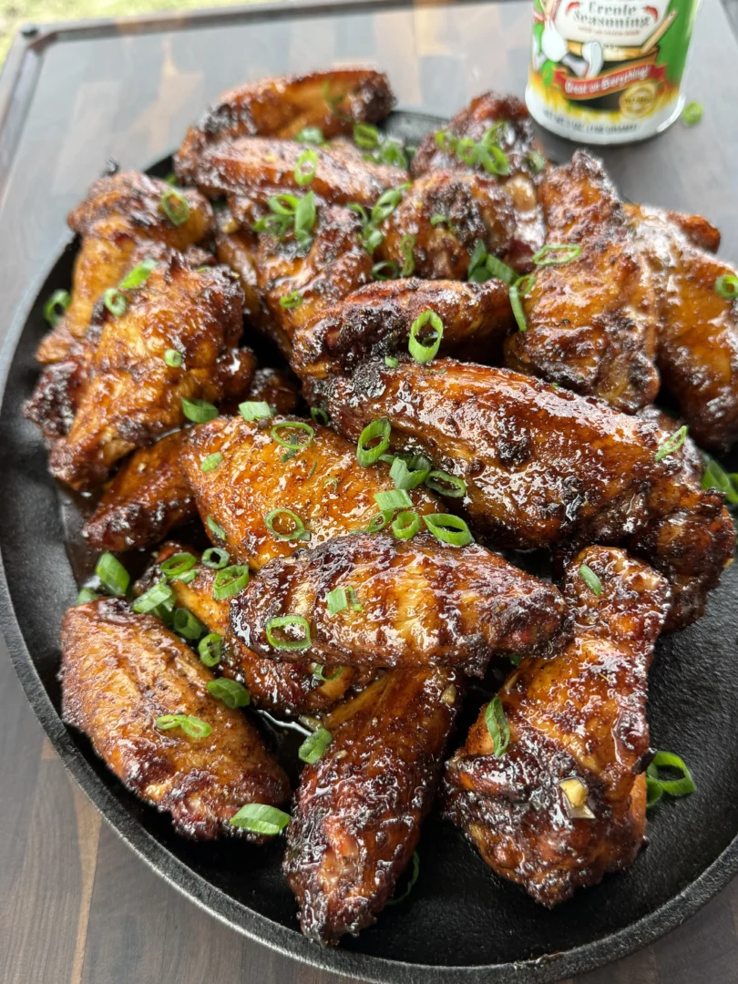Garnishing hot honey chicken wings with fresh parsley.