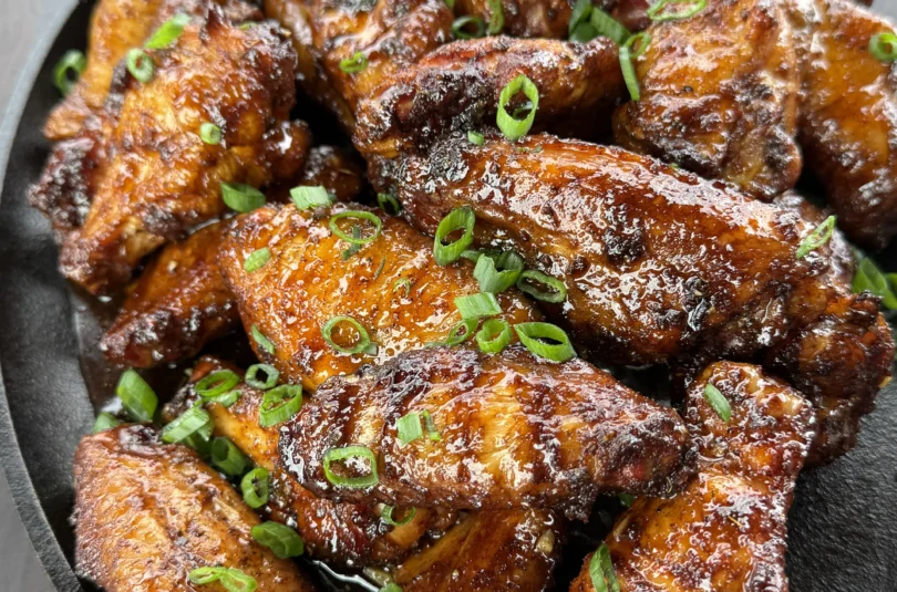 Garnishing hot honey chicken wings with fresh parsley.