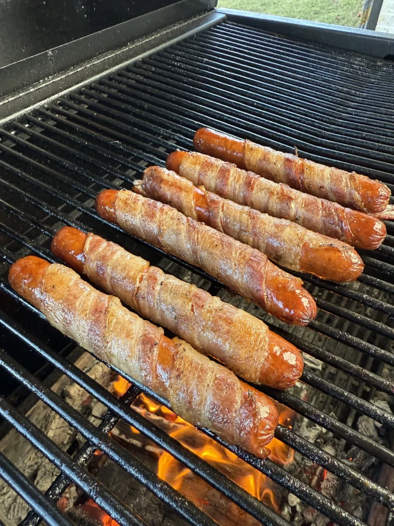 bacon wrapped hot dogs on the grill