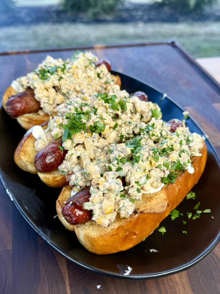 all the elote dogs on a plate