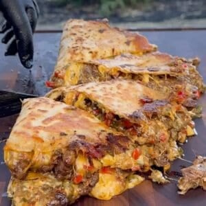 chili lime steak Fajita quesadillas on a flat-top grill, oozing with melted cheese and juicy steak.