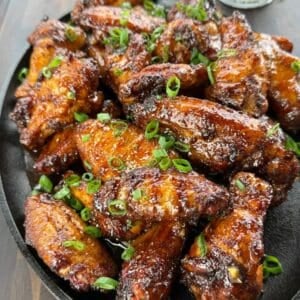 Smoked hot honey chicken wings coated in a sticky glaze with Parmesan and green onions