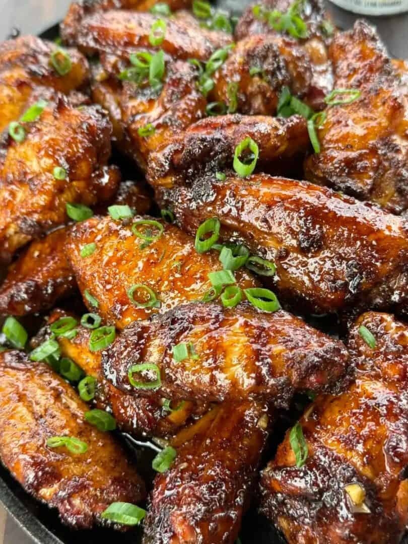 Smoked hot honey chicken wings coated in a sticky glaze with Parmesan and green onions
