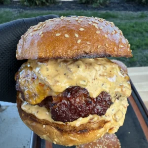 Close-up of melted cheese oozing from a smoked burger patty