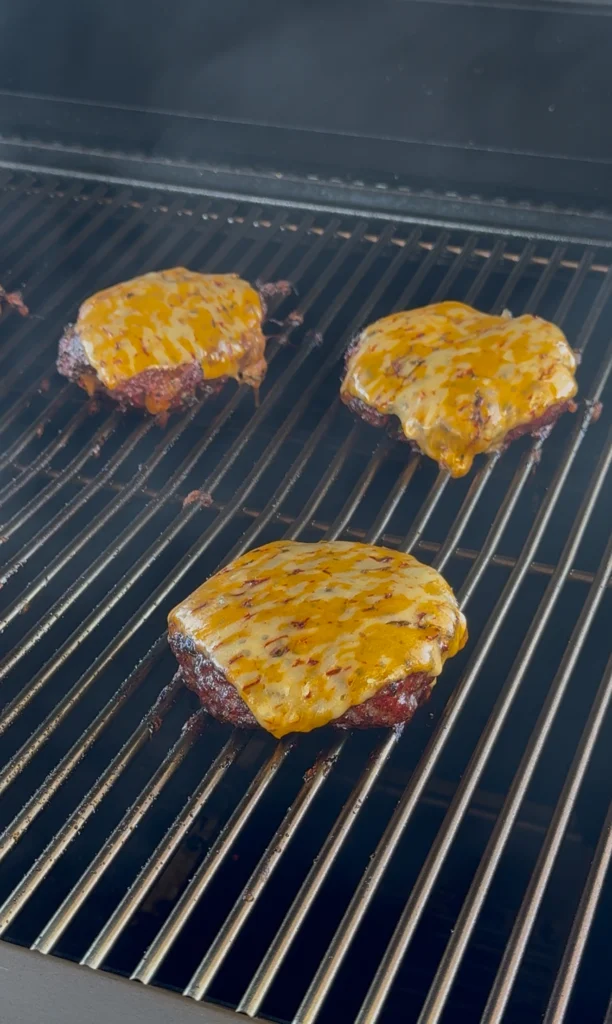 burger on the grill with melted pepper jack cheese
