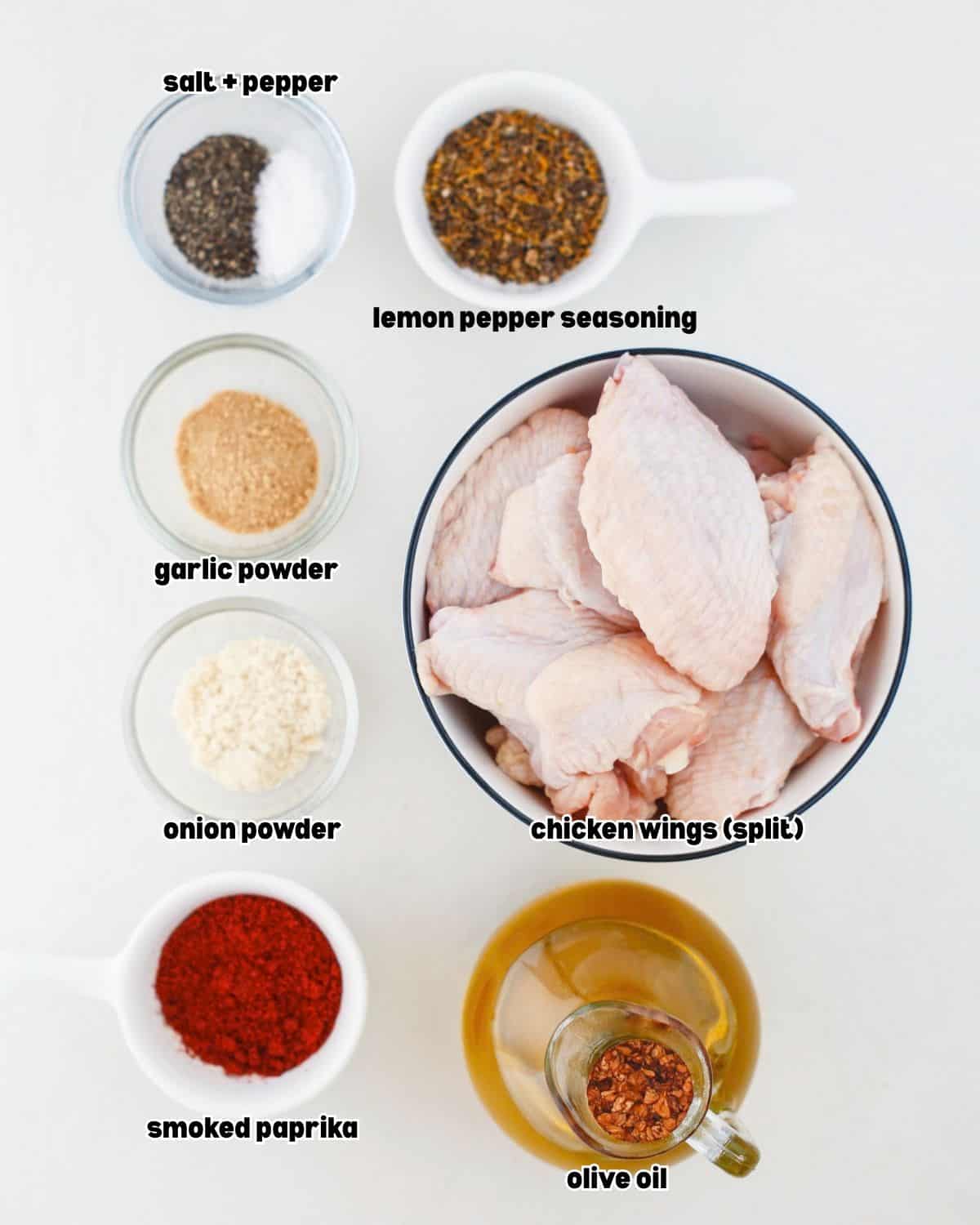 ingredients for smoked garlic lemon pepper chicken wings arranged in bowls, placed on a kitchen countertop.