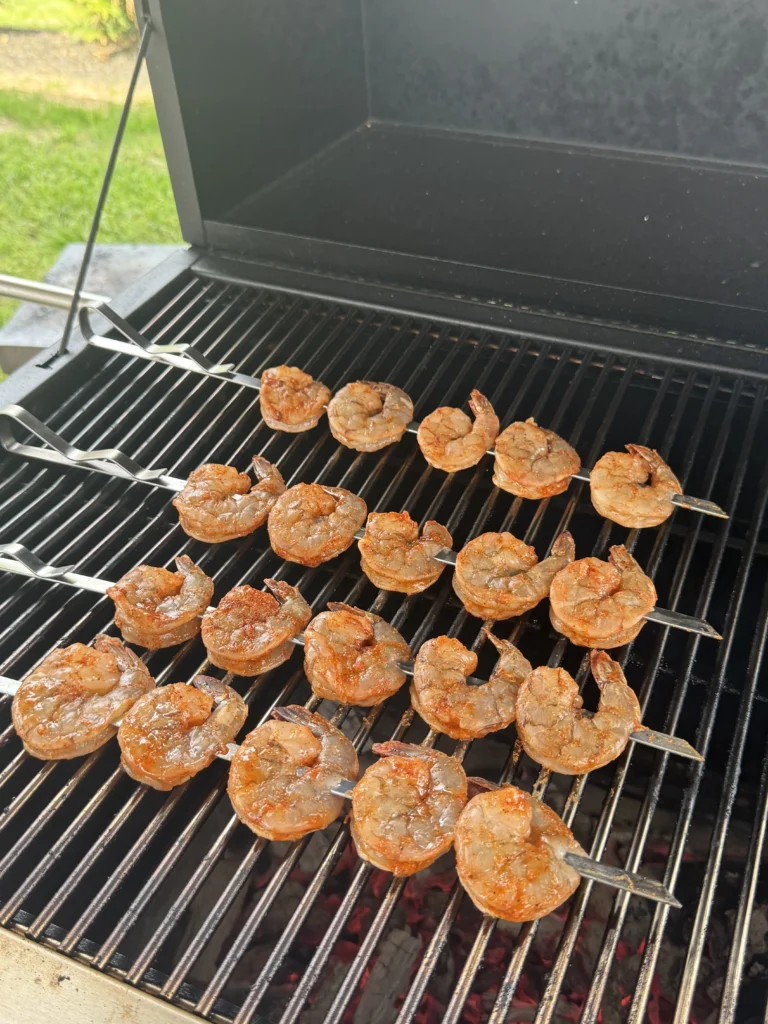 Shrimp skewers placed on hot grill grates