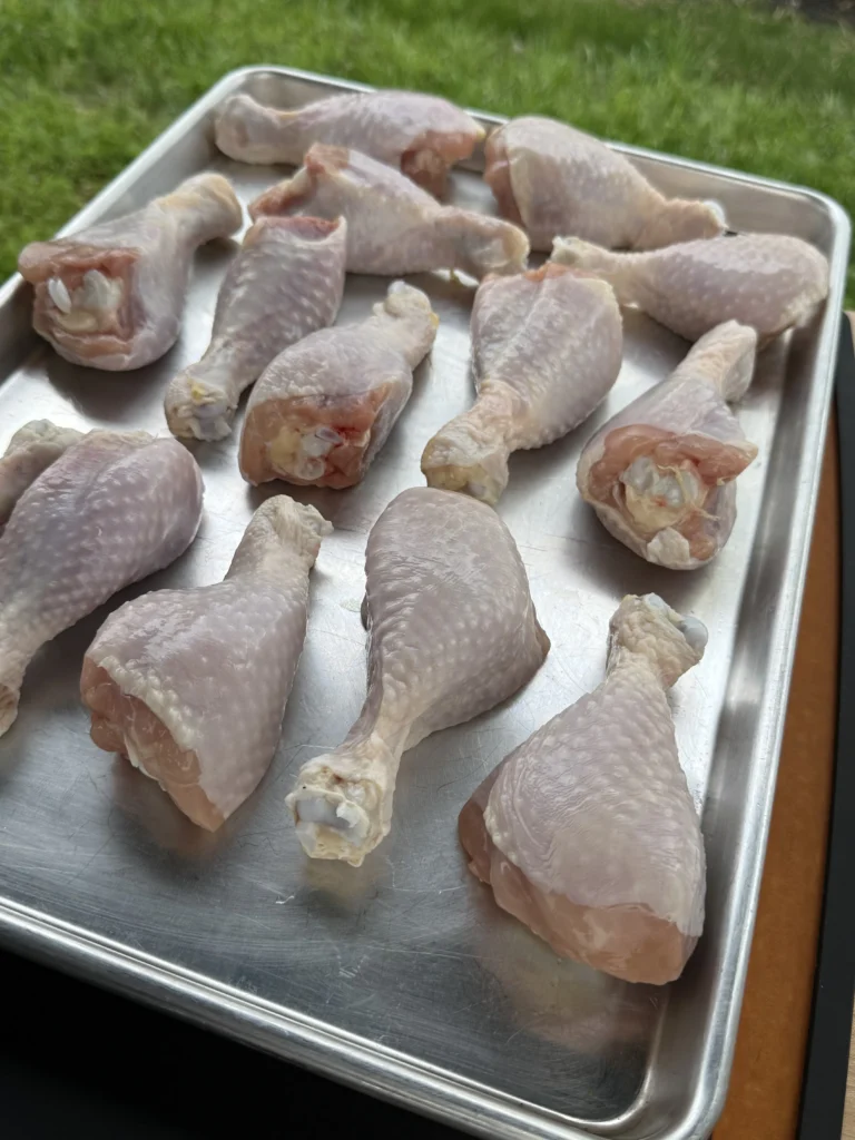 chicken drumsticks on a metal sheet