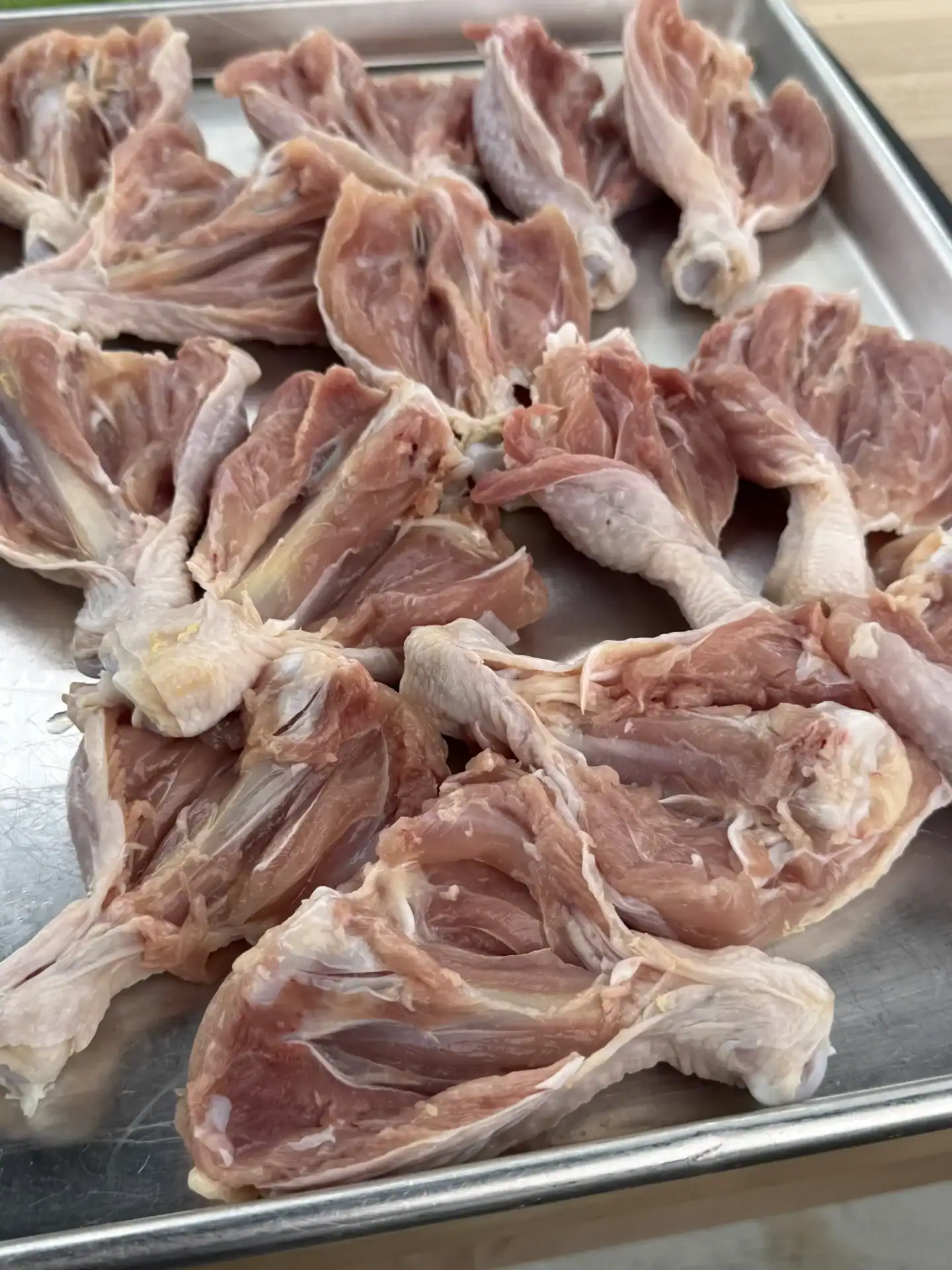Raw chicken drumsticks butterflied around the bone with a paring knife