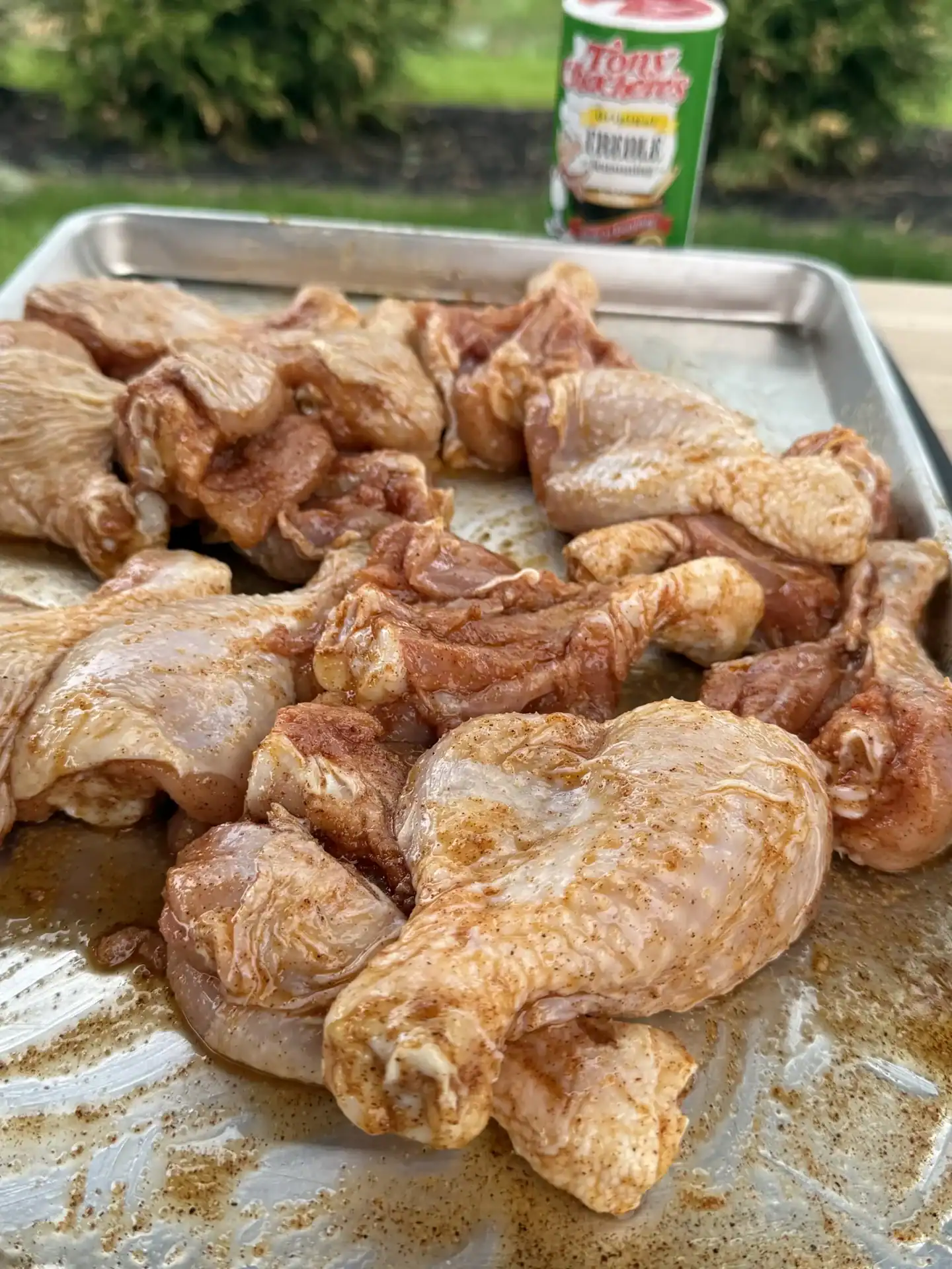 Butterflied chicken drumsticks coated with oil and creole seasoning before grilling