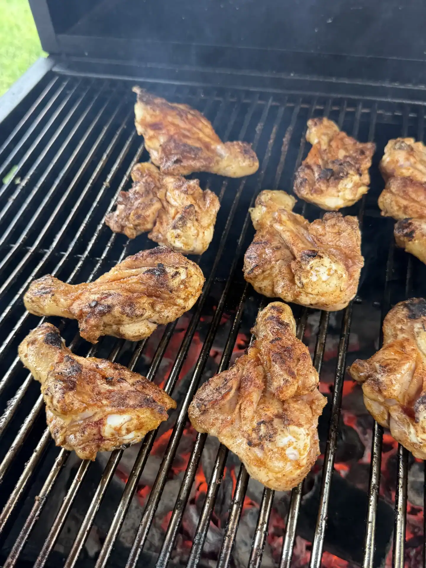 Butterflied chicken drumsticks searing over direct heat on the grill