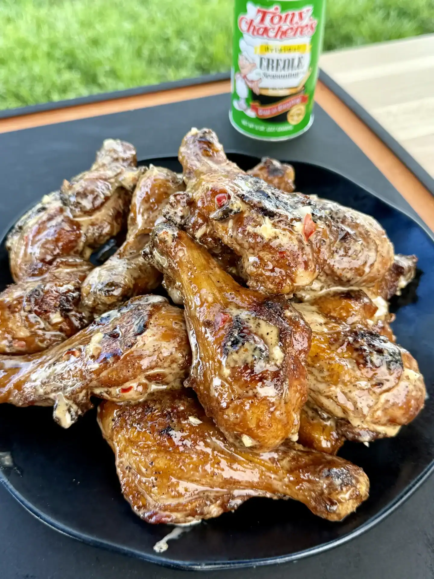 Grilled butterflied chicken drumsticks coated in Bang Bang sauce