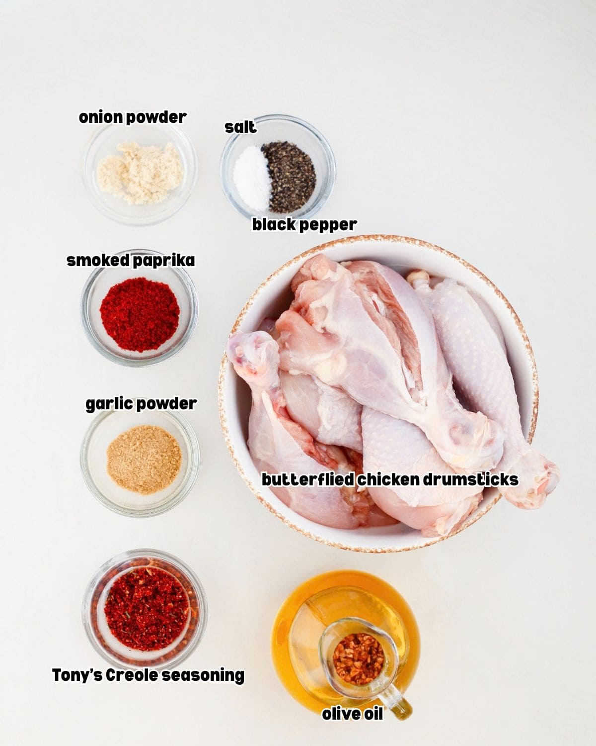 ingredients for grilled butterflied chicken drumsticks placed in bowls on a kitchen countertop.