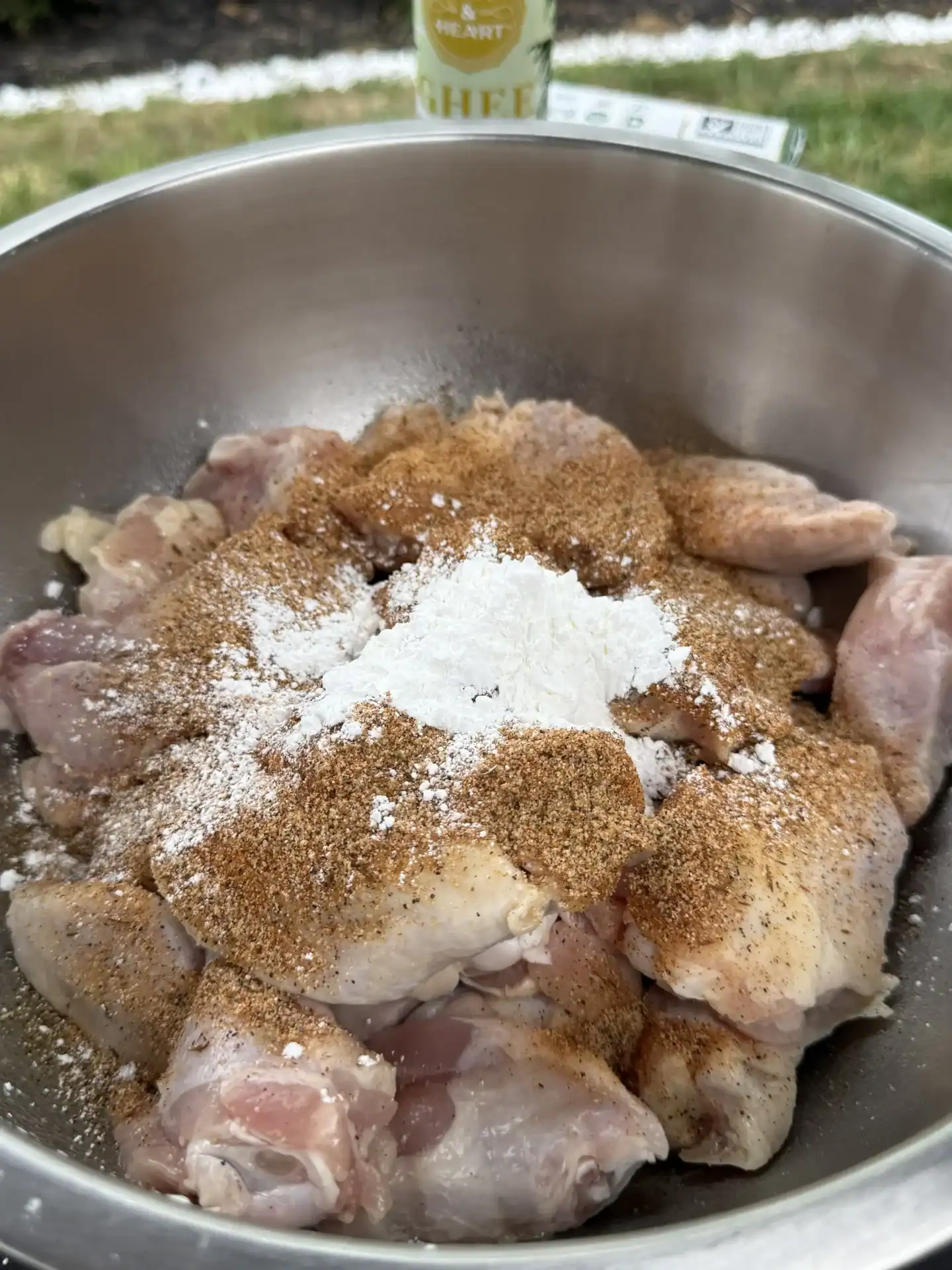 bowl of raw chicken wings with garlic powder, onion powder and other seasonings added in.