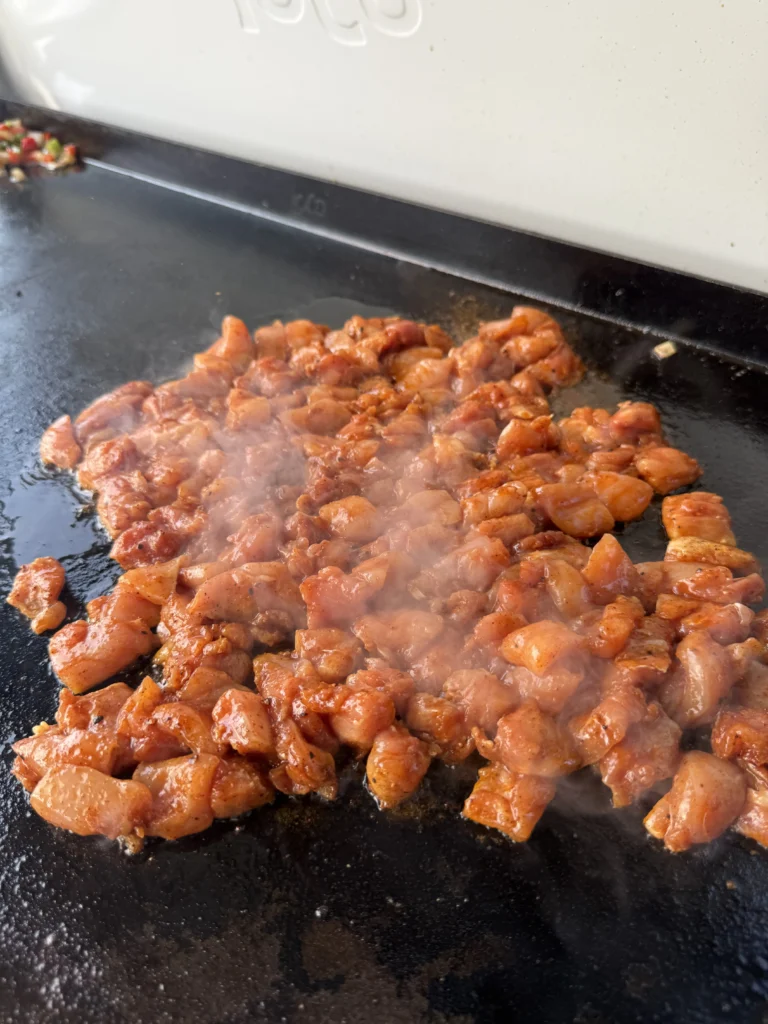 chicken breast cooking on a griddle